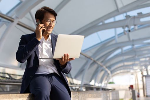 Person med computer som snakker i telefon